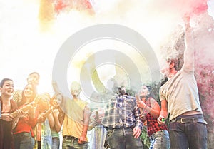 Happy friends using smoke bombs colors at party festival outdoor - Young students having fun and celebrating together - Youth and