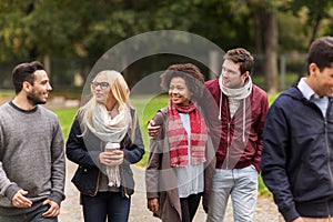 Happy friends walking along autumn park