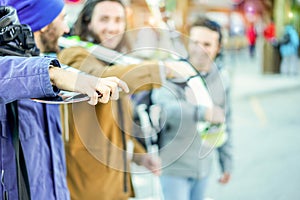 Happy friends walking to ski lift with snow sport equipment - Young people having fun in winter resort vacation - Happiness and