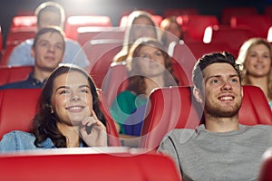 Happy friends watching movie in theater