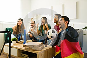 Happy friends watching the soccer world cup together