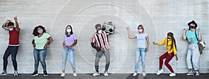 Happy friends wearing face mask listening music with vintage boombox outdoor - Multiracial young people having fun dancing