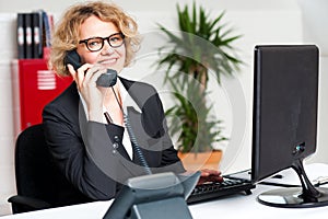 Happy front desk lady attending clients call