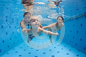 Happy full family swim and dive underwater in swimming pool