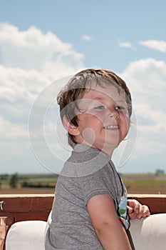 Happy with the fullness of life as a child, a little boy smiles.