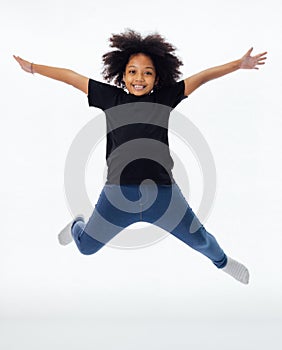 Happy and fun African American black kid jumping with hands raised isolated over white background.
