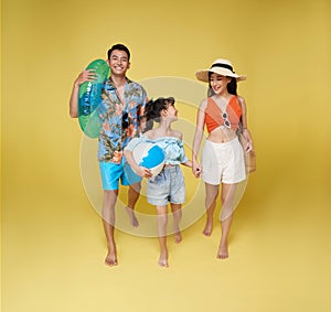 Happy fun asian family vacation portrait. Father, mother and daughter holding beach ball enjoying summer beach