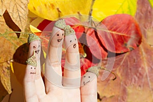 Happy fun autumn acorn family against colorful leaves fall background concept