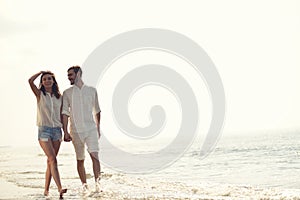 Happy fun beach vacations couple walking together laughing having fun on travel destination.