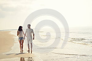 Happy fun beach vacations couple walking together laughing having fun on travel destination.