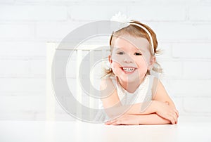 Happy fun funny girl child laughing at empty white table