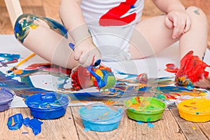 happy funny boy child draws laughing shows hands dirty with paint