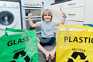 Happy funny boy after sorting garbage at home kitchen. Paternts are teaching kid how to recycle help the boy aware