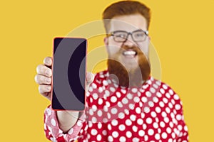 Happy funny fat man shows mobile phone screen presenting mobile application, offer or website.