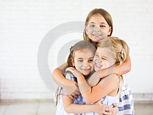 Happy funny girls embrace together