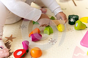 happy funny kid curly baby girl with educational toy blocks flowers. Children play at day care or preschool. Mess in