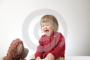 Happy funny little girl emotional playing. cute caucasian blond baby girl