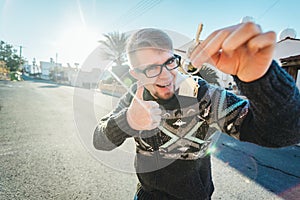 Happy funny man holds house keys on house shaped keychain in front of a new home