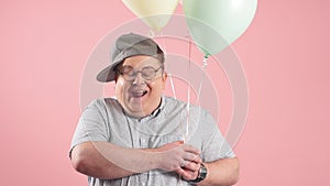 Happy funny man much similar to Winnie the Pooh with air baloons isolated over pink background