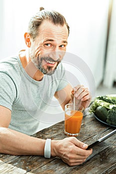 Happy funny man smiling and using the tablet.