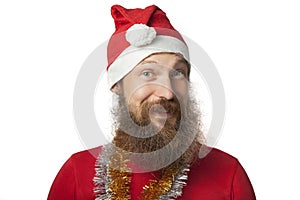 Happy funny santa claus with real beard and red hat and shirt making crazy face and smiling, looking and camera