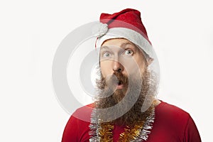 Happy funny santa claus with real beard and red hat and shirt making crazy face and smiling, looking and camera