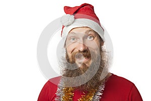 Happy funny santa claus with real beard and red hat and shirt making crazy face and smiling, looking and camera