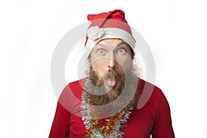 Happy funny santa claus with real beard and red hat and shirt making crazy face and smiling, looking and camera