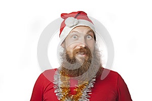 Happy funny santa claus with real beard and red hat and shirt making crazy face and smiling, looking and camera