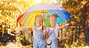 Happy funny sisters twins child girl with umbrella in autumn