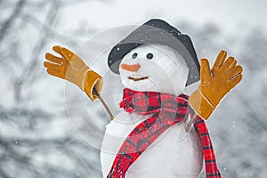 Happy funny snowman in the snow. Snow man in winter hat. Snowman outdoor. Funny snowmen. Cute snowman in hat and scarf