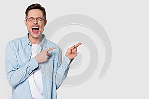 Happy funny man laughing feeling excited pointing finger at copyspace photo