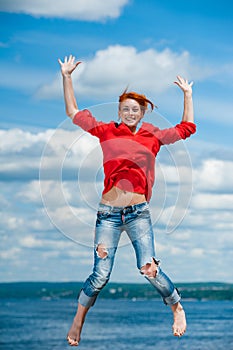 Happy funny young redhead woman jumps