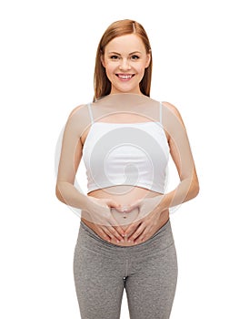 Happy future mother showing heart with her hands