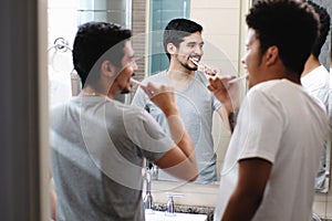 Happy Gay Couple Brushing Teeth In Bathroom