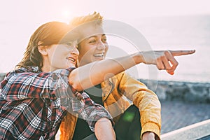 Happy gay couple dating on the beach at sunset - Young lesbians having fun enjoying time together outdoor