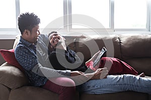 Happy Gay Couple Looking At Pictures On Tablet