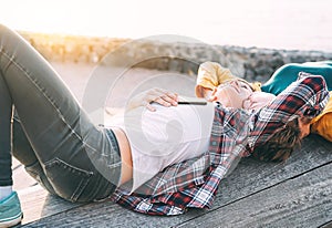 Happy gay couple lying next to the beach at sunset - Lesbian women having a tender romantic moment outdoor