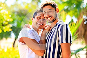 Happy gay couple spending time together in sunny day in green park