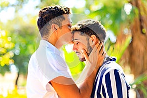 Happy gay couple spending time together in sunny day in green park