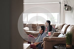 Happy Gay Couple Watching Sports Game On TV At Home