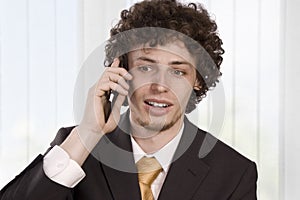 Happy gesturing business man with mobile phone