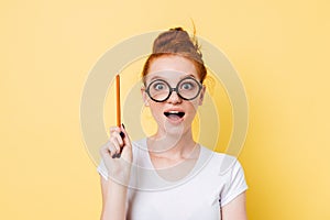 Happy ginger woman in eyeglasses having idea