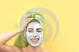 Happy girl applying facial clay mask - Young woman having skin care spa day - Beauty clean treatment day and cosmetology products