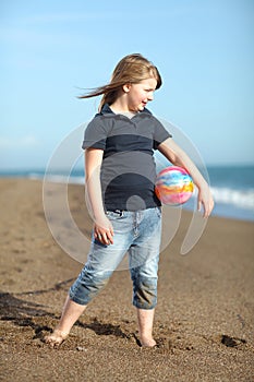 Happy girl with ball on the beach