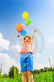 Happy girl with balloons wearing flower circlet