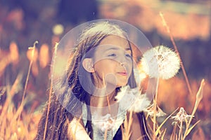 Happy girl blowing dandelion flower