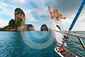 Happy girl on board of sailing yacht have a fun.