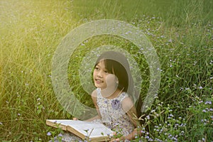 Happy girl with a book in the park