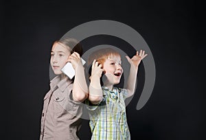 Happy girl and boy, children speak on mobile phones